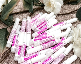 Puede incluir: Un montón de botellas de pegamento para uñas blancas con etiquetas rosas que dicen "KDS Professional Nail Products" y "Nail Glue".