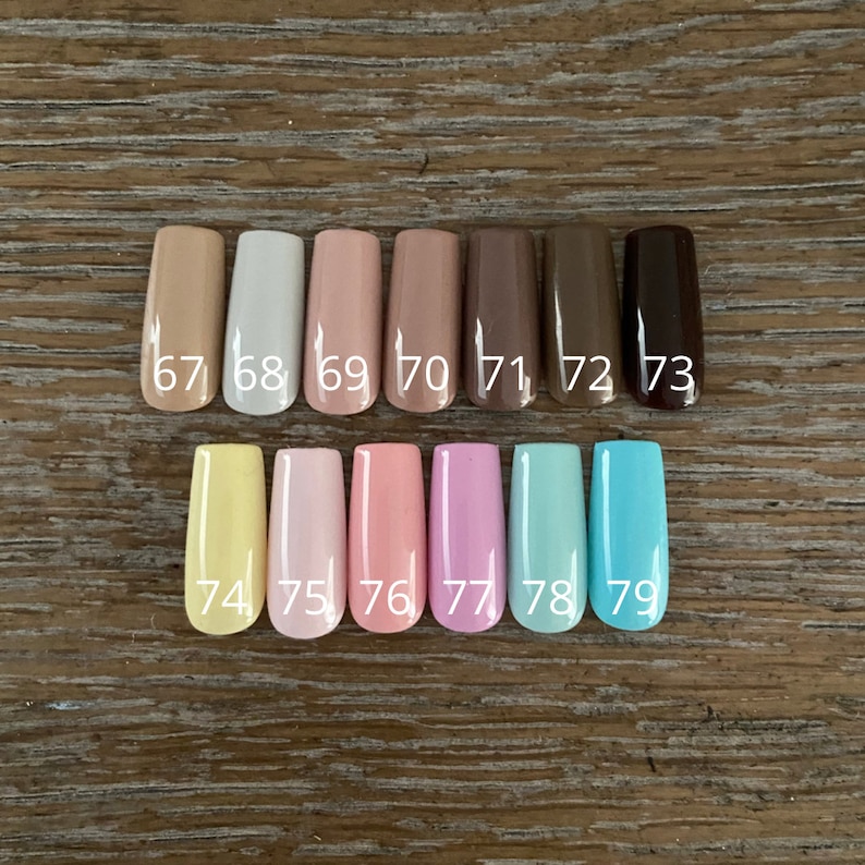May include: A row of 12 nail polish colors in a variety of shades, including beige, light pink, light blue, and brown. The colors are numbered 67 through 79.