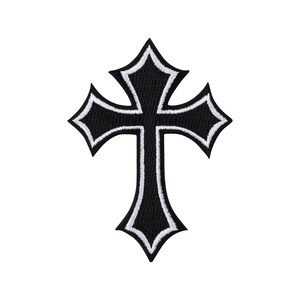 Puede incluir: Un parche bordado negro con forma de cruz y extremos puntiagudos. La cruz presenta un centro negro grueso delineado por un borde blanco fino, creando un diseño de alto contraste con costuras visibles en toda la superficie.