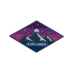 Puede incluir: Parche en forma de diamante con una cordillera bajo un cielo púrpura y azul oscuro con estrellas y una luna llena. La palabra "EXPLORER" está bordada en blanco. El parche tiene un borde azul oscuro.