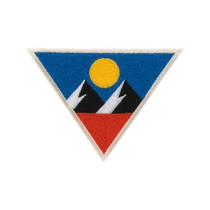 Puede incluir: Parche bordado de forma triangular con un paisaje montañoso. El diseño incluye un cielo azul, un sol amarillo, dos montañas negras con picos blancos y una base roja. El parche tiene un borde blanco.