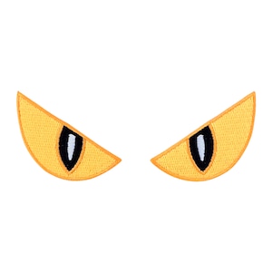 Könnte beinhalten: Zwei gestickte Aufnäher in Form stilisierter gelber Augen. Jedes Auge hat eine schwarze Pupille mit einem weißen Glanzlicht. Die Aufnäher sind mit einem dunkleren gelben Faden umrandet.