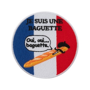 Op de afbeelding: Geborduurde patch met een Frans vlagontwerp. De patch toont een cartoon baguette met een baret en een baguette. De tekst op de patch luidt "JE SUIS UNE BAGUETTE" en "Oui, oui... baguette."