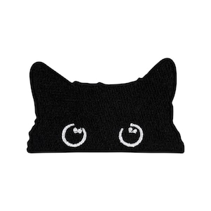 Può includere: Toppa in feltro nero a forma di viso di gatto con occhi ricamati bianchi.