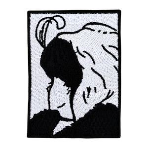 May include: Black and white embroidered patch of a woman with her head covered by a cloth. The woman's face is visible and she is looking down.