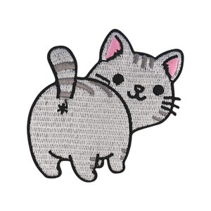 May include: Embroidered iron-on patch of a grey cat with pink ears, looking over its shoulder with a cute expression. The cat's tail is sticking up in the air.