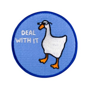 Op de afbeelding: Een blauwe en witte geborduurde patch met een witte gans die een zonnebril draagt en de tekst "DEAL WITH IT".
