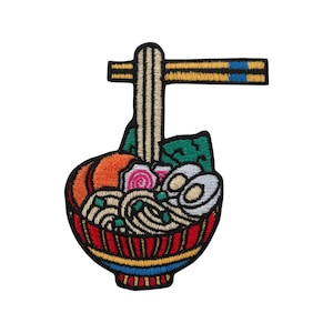 Könnte beinhalten: Gestickter Aufnäher mit einer Schüssel Ramen mit Nudeln, Gemüse und einem Ei. Die Schüssel ist rot mit gelben und blauen Akzenten. Ein Paar Essstäbchen befindet sich über der Schüssel. Auf weißem Hintergrund.