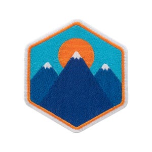 May include: Embroidered patch depicting a mountain scene with a rising sun. The design shows three blue mountains with white snow caps, an orange sun, and a turquoise sky, framed by a white and orange hexagonal border. Ideal for customising clothing or accessories.