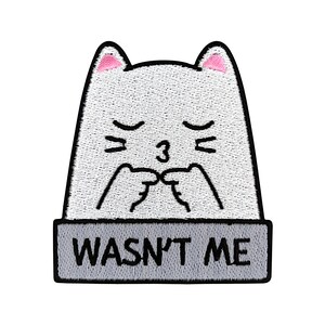 May include: White embroidered iron-on patch of a cartoon cat with pink ears, closed eyes, and a 3 on its nose. The cat is blowing a kiss and the text below reads "Wasn't Me".