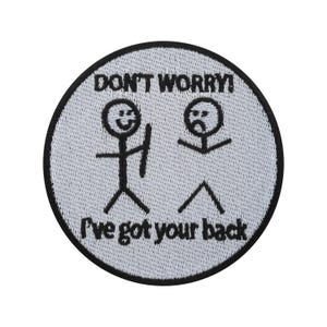 Op de afbeelding: Een ronde, geborduurde patch met een witte achtergrond en een zwarte rand. De patch toont stokfiguren en de zinnen "DON'T WORRY!" en "I've got your back" in zwarte tekst. Eén stokfiguur lacht, de andere fronst.
