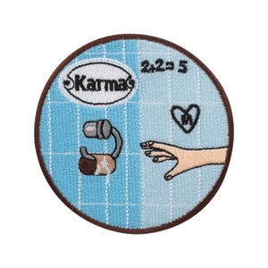 Puede incluir: Parche redondo con borde marrón y fondo azul claro dividido en dos secciones. Una sección tiene la palabra "Karma's" en un óvalo blanco. La otra sección tiene el texto "2+2=5", un corazón y una mano.