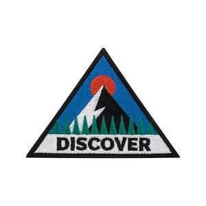May include: Triangular embroidered patch with a black border. The design depicts a mountain scene with a black mountain, white lightning bolt, red sun, and green trees. The word "DISCOVER" is embroidered in white.