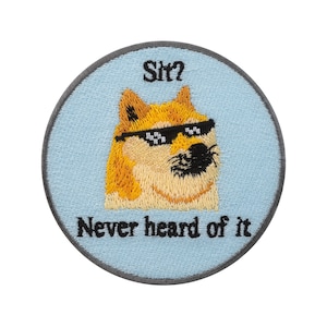 Könnte beinhalten: Runder, gestickter Aufnäher mit hellblauem Hintergrund und einem Hund im Meme-Stil mit Sonnenbrille. Der Text "Sit?" steht über dem Hund und "Never heard of it" darunter. Der Aufnäher hat einen grauen Rand.