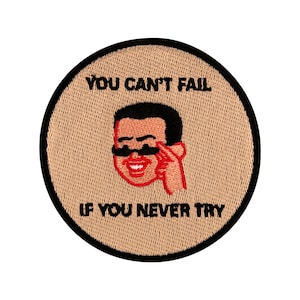 Könnte beinhalten: Ein beiger runder Patch mit schwarzen Nähten und dem Text "You can't fail if you never try" in Schwarz. Eine Cartoon-Illustration einer Person mit einem Schnurrbart und einer Sonnenbrille befindet sich in der Mitte des Patches.