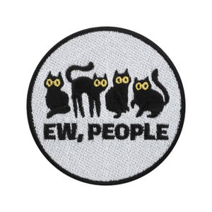 Può includere: Toppa rotonda con sfondo bianco e bordo nero. Presenta quattro sagome di gatti neri con occhi gialli. Il testo "EW, PEOPLE" è ricamato in nero sotto. Adatta per abbigliamento o accessori.