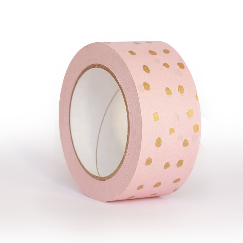 K&ouml;nnte beinhalten: Eine Rolle rosa Washi-Tape mit goldenen Punkten.