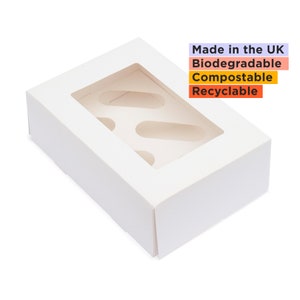 May include: White cardboard box with a window, designed to hold cupcakes or other treats. The box has three circular cutouts for cupcakes and the text "Made in the UK, Biodegradable, Compostable, Recyclable" printed on the side.