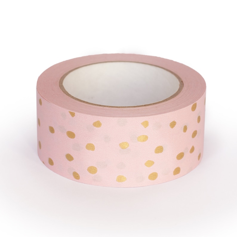 K&ouml;nnte beinhalten: Eine Rolle rosa Washi-Tape mit goldenen Punkten.