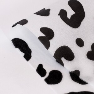 May include: White tissue paper with a black and white leopard print pattern.