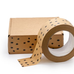 May include: A roll of brown packing tape with black polka dots. The tape is partially unwound and is next to a brown cardboard box with black polka dots.