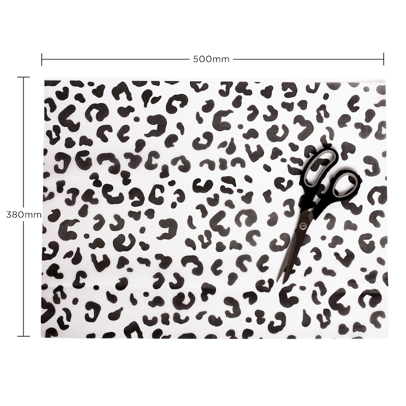May include: Black and white leopard print wrapping paper with a pair of scissors on top. The paper measures 380mm by 500mm.