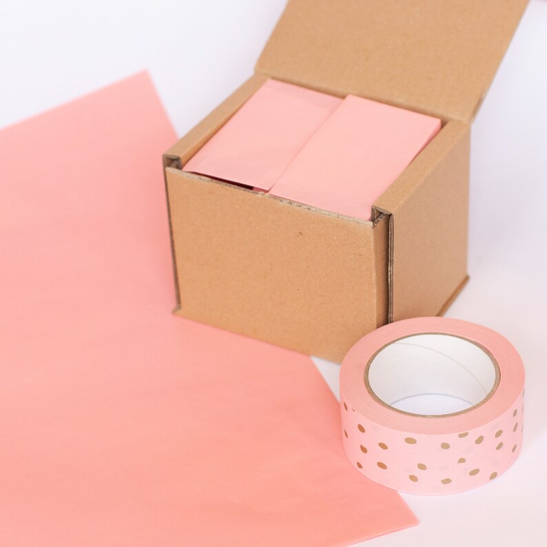 May include: A cardboard box with a pink paper liner and a roll of pink and gold polka dot washi tape.