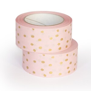 K&ouml;nnte beinhalten: Zwei Rollen rosa Washi-Tape mit goldenen Punkten.