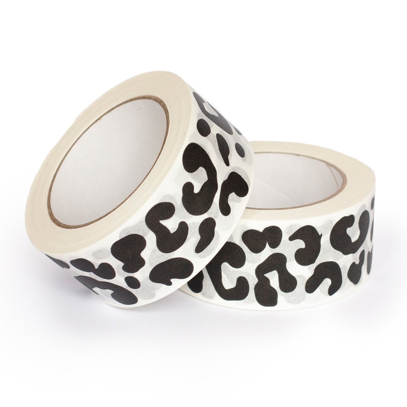 May include: Two rolls of white tape with a black leopard print design.