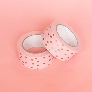 May include: Two rolls of pink washi tape with gold polka dots.