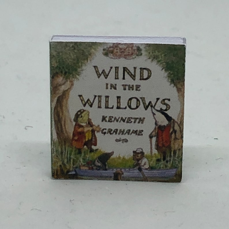 Puede incluir: Una cubierta de libro vintage con el t&iacute;tulo "El viento en los sauces" de Kenneth Grahame. La cubierta presenta ilustraciones de personajes animales en un barco.
