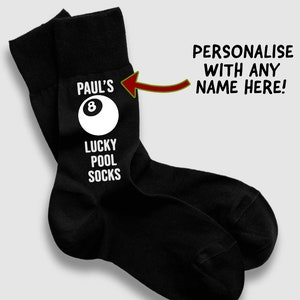 Może przedstawiać: Czarne skarpetki z napisem "PAUL'S 8 LUCKY POOL SOCKS" i białą grafiką kuli bilardowej z ósemką. Widoczny jest również tekst "SPERSONALIZUJ Z DOWOLNYM IMIENIEM TUTAJ!". Zabawny prezent dla graczy w bilard.