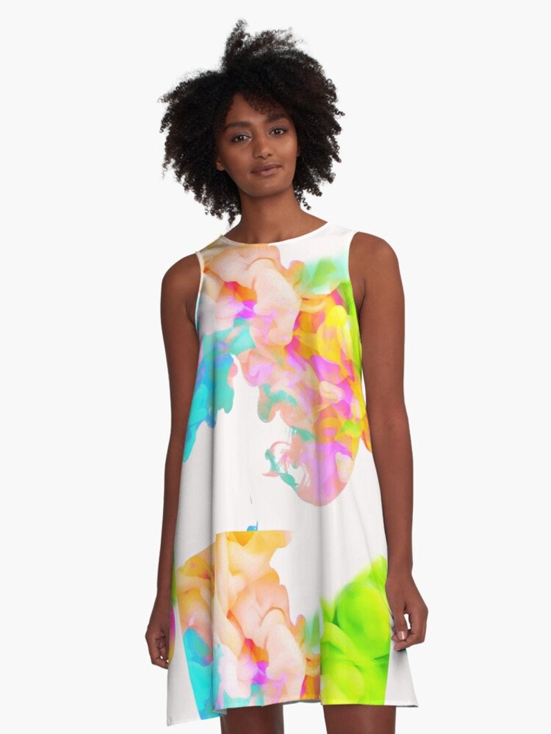 May include: A white sleeveless dress with a colorful abstract print of swirling colors, including pink, blue, green, and yellow.