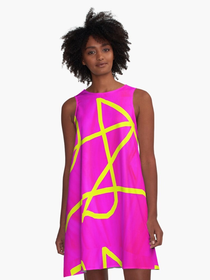 May include: A sleeveless pink dress with a yellow abstract design. The dress has a flowy, A-line silhouette.