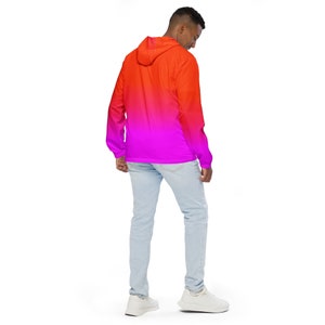 Pu&ograve; includere: Una giacca con cappuccio con un design sfumato che passa dal rosso al rosa. La giacca &egrave; indossata da una persona con jeans blu chiaro e scarpe da ginnastica bianche.