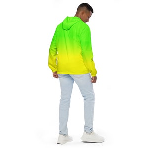 May include: A hooded jacket with a green to yellow ombre design. The jacket is made of a lightweight material and has a zipper closure.