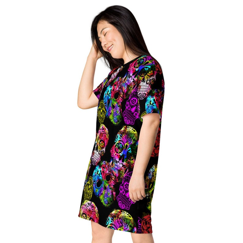 May include: A black t-shirt dress with a colorful sugar skull print. The skulls are in shades of pink, purple, green, and blue.