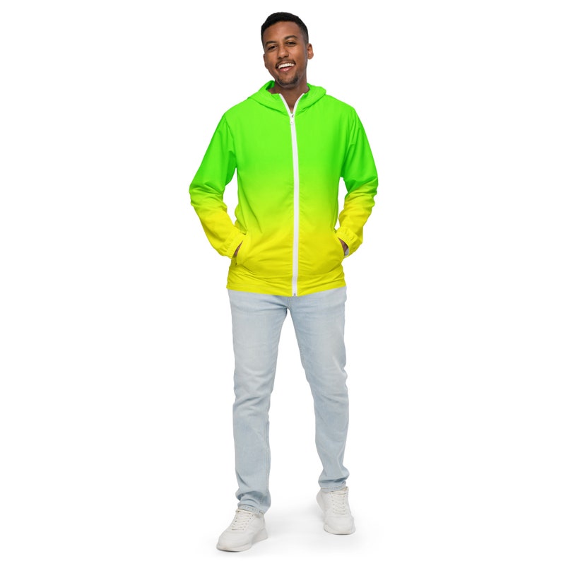 May include: A person wearing a green and yellow ombre hooded jacket with a white zipper. The jacket has a drawstring hood and pockets on the sides.