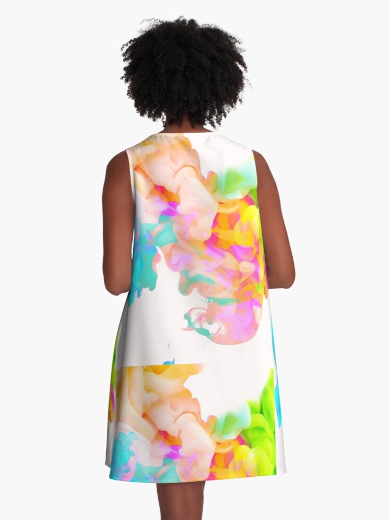 May include: A sleeveless dress with a white background and a colorful abstract design. The design features swirls of pink, blue, green, and yellow.