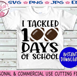 May include: A white short-sleeved t-shirt featuring the black text I TACKLED 100 DAYS OF SCHOOL with two brown footballs replacing the zeros in the number 100. The design is centered on the front of the shirt with bold, black lettering.