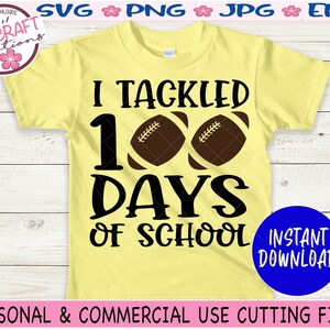 May include: A pale yellow short-sleeve t-shirt featuring the black text I TACKLED 100 DAYS OF SCHOOL with two brown footballs replacing the zeros in 100. The design is centered on the front of the shirt, which is displayed flat.