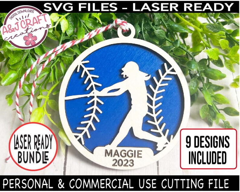 May include: A blue and white baseball-themed wooden ornament with a silhouette of a softball player and the text "MAGGIE 2023".