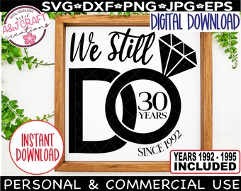 May include: A white sign with a black wooden frame. The sign says "We Still Do" with a diamond ring and a circle with the number 30 and the words "Years" and "Since 1992".