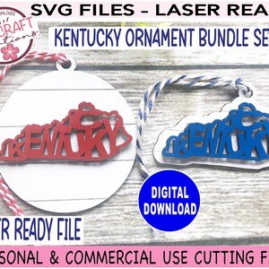 May include: Two laser-cut Kentucky state outline ornaments, one red and one blue, with the word "Kentucky" spelled out inside the state shape. The ornaments are on a white wood background with a red and white twine string attached to each.