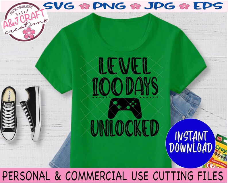 May include: Green t-shirt with black text that reads "Level 100 Days Unlocked" and a black video game controller graphic.  The text is surrounded by a dotted line.