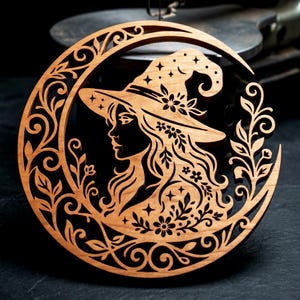 May include: A circular wooden wall hanging featuring a laser-cut design of a person wearing a wide-brimmed hat adorned with stars and flowers. The figure is framed by a crescent moon shape decorated with intricate swirling vines and leaf patterns.