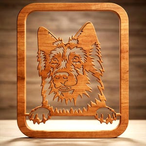 Peut inclure: Une décoration murale en bois brun clair présentant une silhouette découpée au laser d'une tête de chien berger allemand avec des oreilles pointues et des pattes reposant sur le bord inférieur du cadre, le tout dans un cadre rectangulaire.