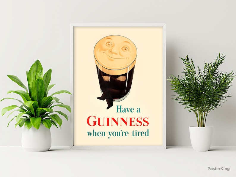 May include: Framed vintage-style Guinness advertisement. The image features a smiling pint of Guinness with arms and legs, above the text "Have a Guinness when you're tired" in red and teal.