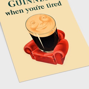 K&ouml;nnte beinhalten: Ein Vintage-Poster mit einem Guinness-Pint mit einem l&auml;chelnden Gesicht, das auf einem kleinen roten Sessel sitzt. Der Text "GUINNESS when you're tired" ist in dunkler gr&uuml;ner Schrift auf cremefarbenem Hintergrund zu sehen, was an eine klassische Pub-Werbung erinnert.