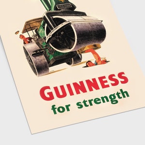May include: Vintage Guinness advertisement poster. The image features a steamroller with a man holding a pint of Guinness. The text reads "GUINNESS for strength" in red and green. The poster has a cream-colored background.